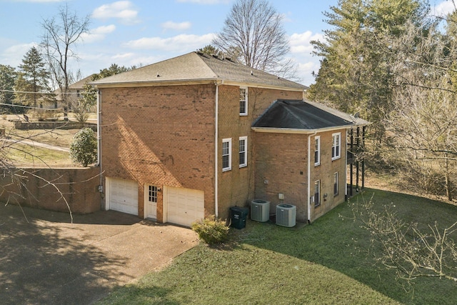 view of home's exterior featuring a garage, a lawn, and cooling unit