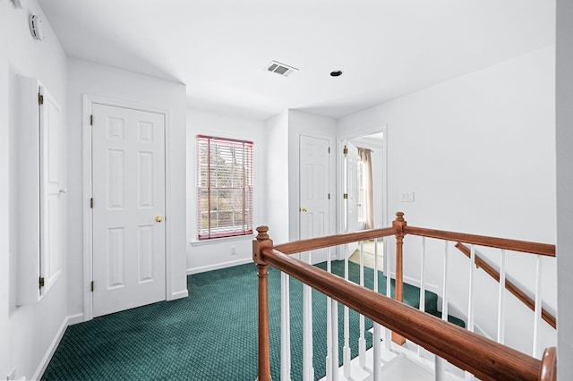 hallway with dark colored carpet