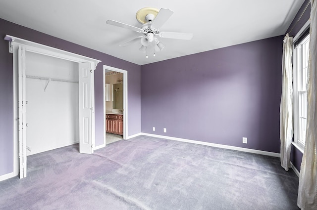 unfurnished bedroom with carpet, a closet, ceiling fan, and ensuite bath