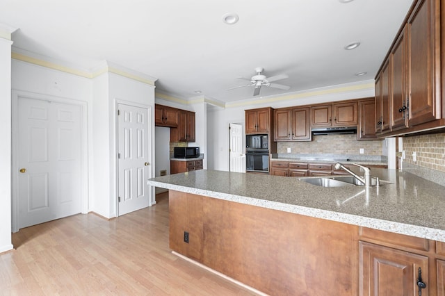 kitchen featuring light wood-type flooring, kitchen peninsula, black appliances, sink, and decorative backsplash