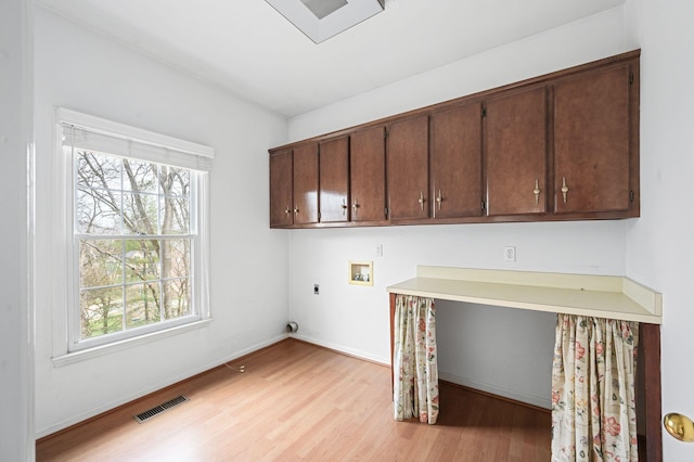 laundry area featuring cabinets, hookup for an electric dryer, washer hookup, and light hardwood / wood-style flooring