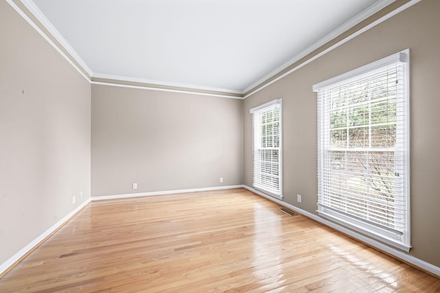 spare room featuring light hardwood / wood-style floors and crown molding