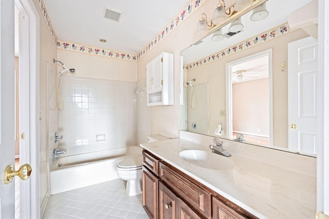 full bathroom featuring tiled shower / bath combo, vanity, toilet, and tile patterned floors