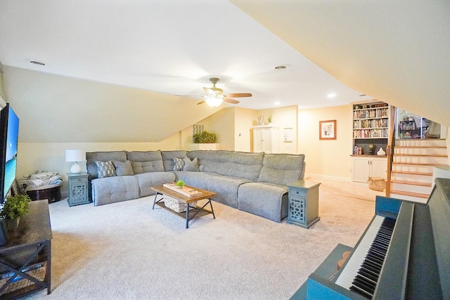 living room featuring built in shelves, ceiling fan, vaulted ceiling, and light carpet