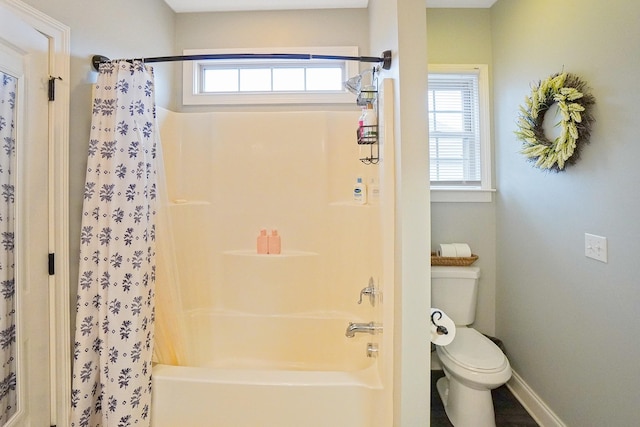 bathroom featuring a healthy amount of sunlight, shower / bathtub combination with curtain, and toilet