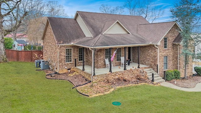 view of front of property featuring a patio, a front yard, and central air condition unit