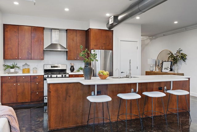 kitchen featuring wall chimney exhaust hood, stainless steel appliances, sink, and a center island with sink