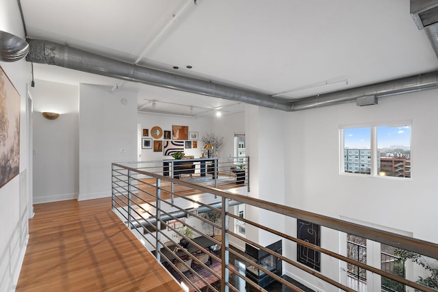 hallway with track lighting and hardwood / wood-style floors