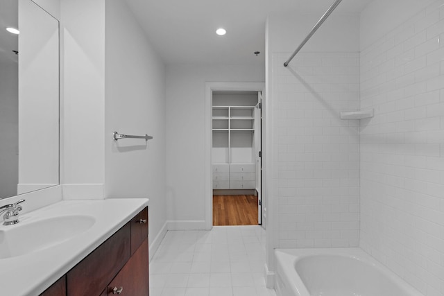 bathroom featuring tiled shower / bath combo, vanity, and tile patterned floors