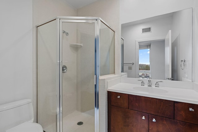 bathroom with vanity, an enclosed shower, and toilet