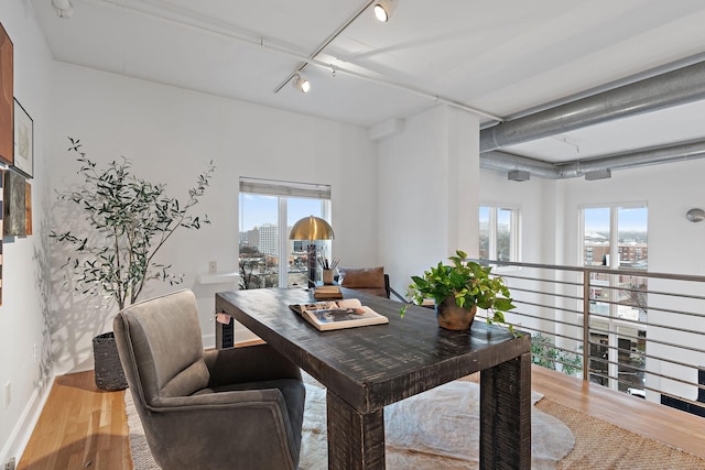 office space featuring wood-type flooring and rail lighting