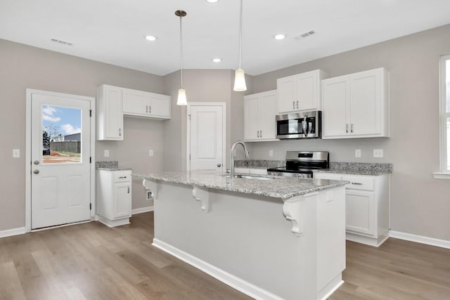 kitchen featuring white cabinetry, an island with sink, appliances with stainless steel finishes, and sink