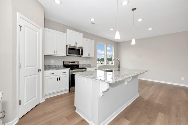 kitchen with sink, white cabinetry, an island with sink, pendant lighting, and stainless steel appliances