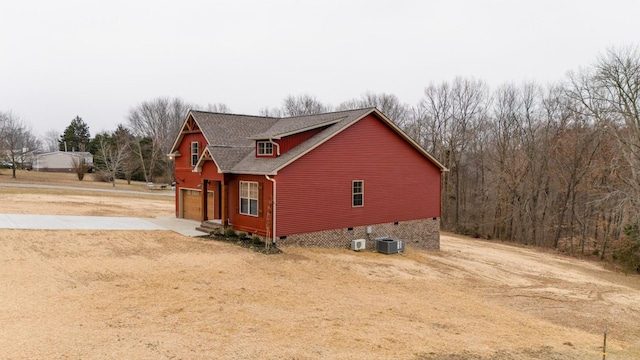 view of side of property with a garage and central AC unit