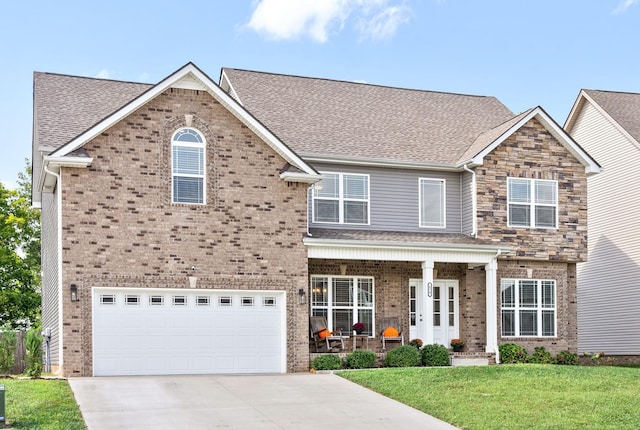 view of front facade featuring a garage, covered porch, and a front yard