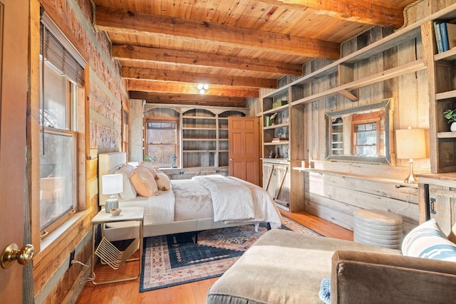 bedroom with wood ceiling, wood-type flooring, beam ceiling, and wood walls