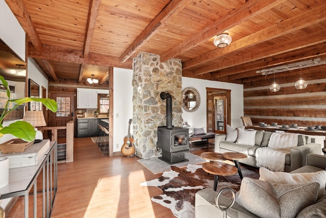 living room featuring wooden ceiling, light hardwood / wood-style floors, beamed ceiling, and a wood stove