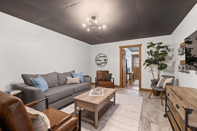 living room with light hardwood / wood-style floors and a notable chandelier