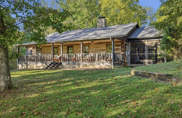 back of property with a porch, a yard, and a sunroom