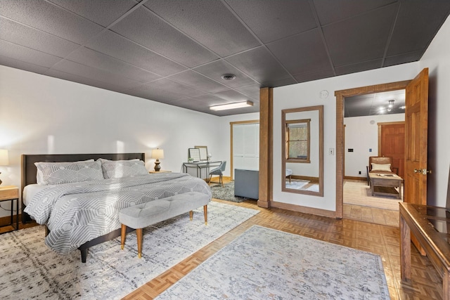 bedroom featuring parquet floors and a paneled ceiling