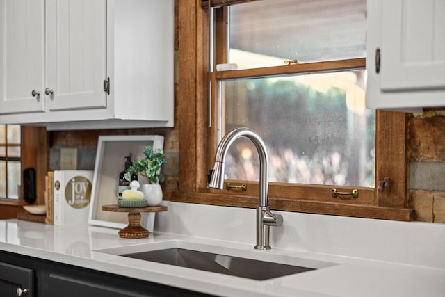 interior details with white cabinetry and sink