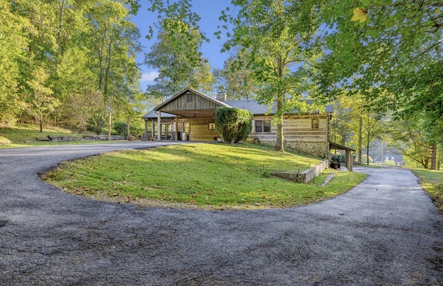 view of front of home with a carport and a front lawn