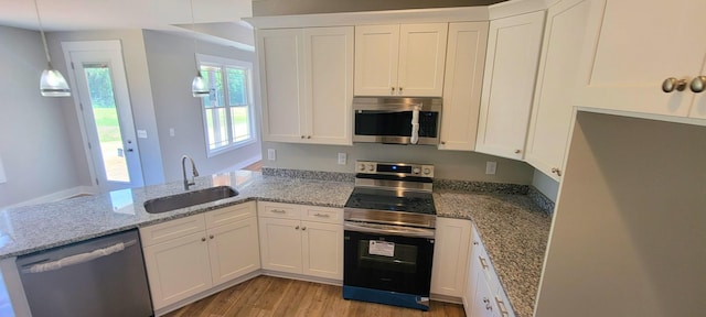 kitchen featuring sink, white cabinetry, light stone counters, hanging light fixtures, and stainless steel appliances