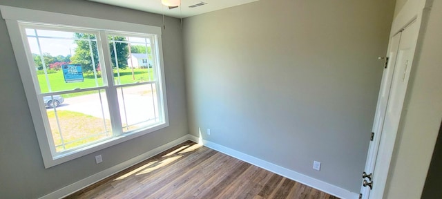 spare room featuring hardwood / wood-style flooring and plenty of natural light