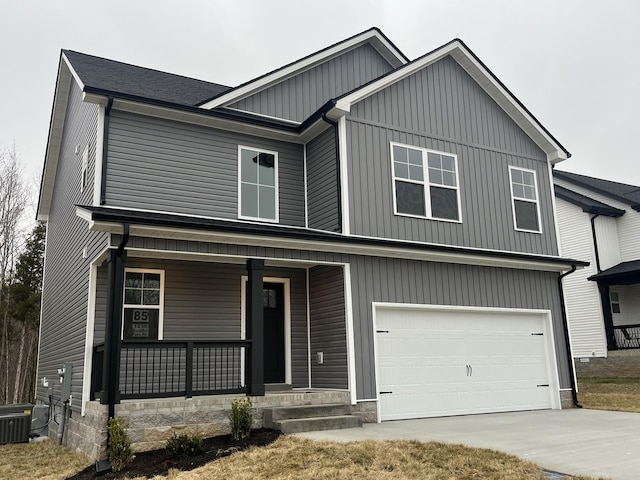 view of front of home featuring a garage, central air condition unit, and a porch