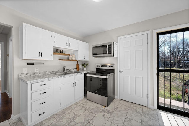 kitchen with plenty of natural light, stainless steel appliances, sink, and white cabinets