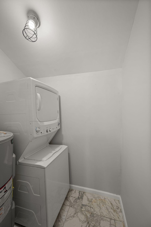 clothes washing area featuring water heater and stacked washer and clothes dryer