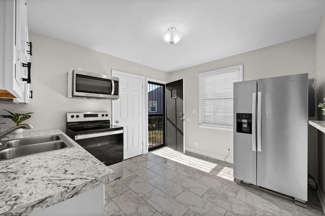 kitchen featuring stainless steel appliances, white cabinetry, and sink