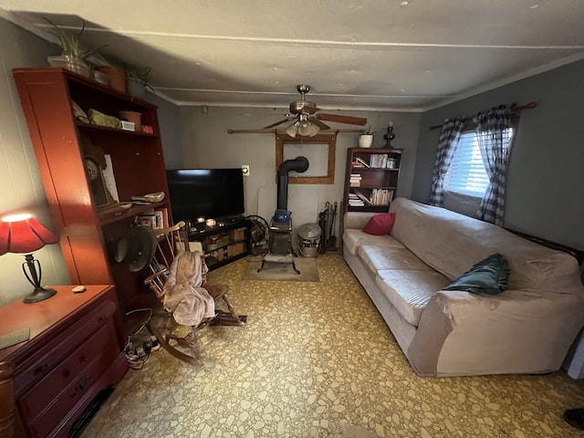 living room with ceiling fan and a wood stove