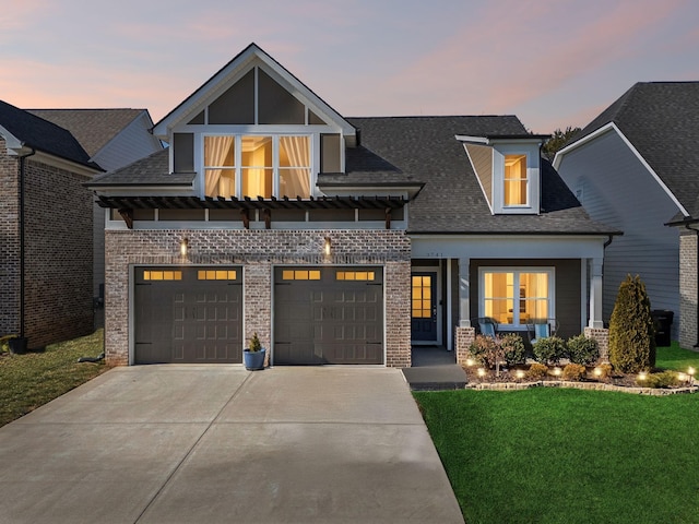 view of front of property featuring a garage and a lawn