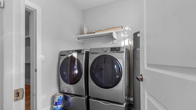 clothes washing area featuring wood-type flooring and washer and dryer