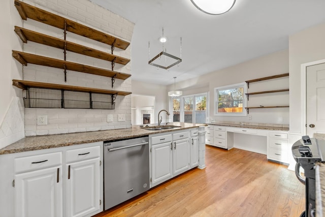 kitchen featuring sink, white cabinetry, light hardwood / wood-style floors, decorative light fixtures, and stainless steel dishwasher