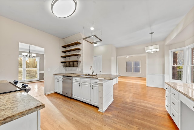 kitchen featuring pendant lighting, sink, white cabinets, and light wood-type flooring