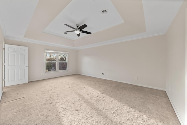 unfurnished room with crown molding, a tray ceiling, light colored carpet, and ceiling fan