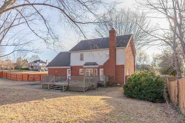 back of house featuring a wooden deck and a yard