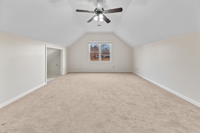 bonus room with vaulted ceiling, light carpet, and ceiling fan