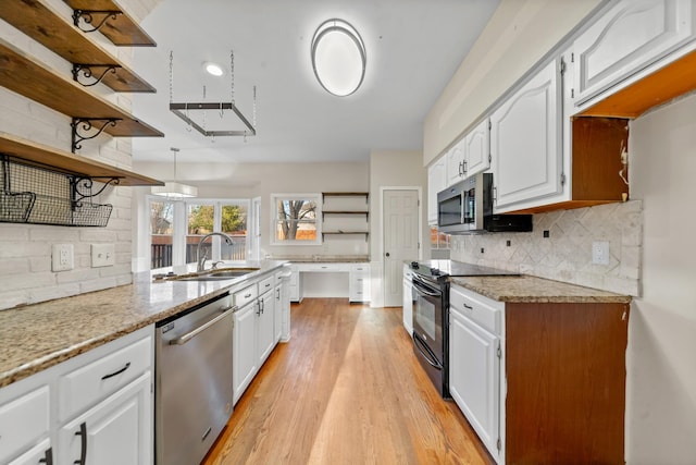 kitchen featuring sink, appliances with stainless steel finishes, tasteful backsplash, white cabinets, and light wood-type flooring