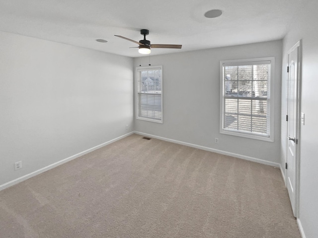 spare room with light colored carpet and ceiling fan