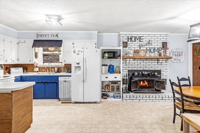 kitchen with blue cabinets, sink, crown molding, white fridge with ice dispenser, and white cabinets