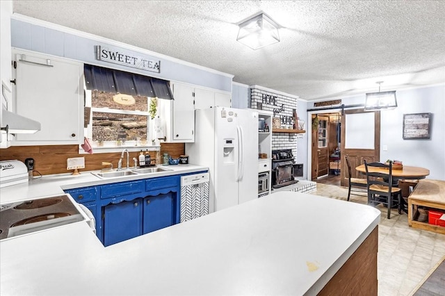 kitchen with sink, white cabinets, a barn door, blue cabinetry, and white appliances