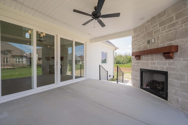 view of patio with ceiling fan and an outdoor stone fireplace