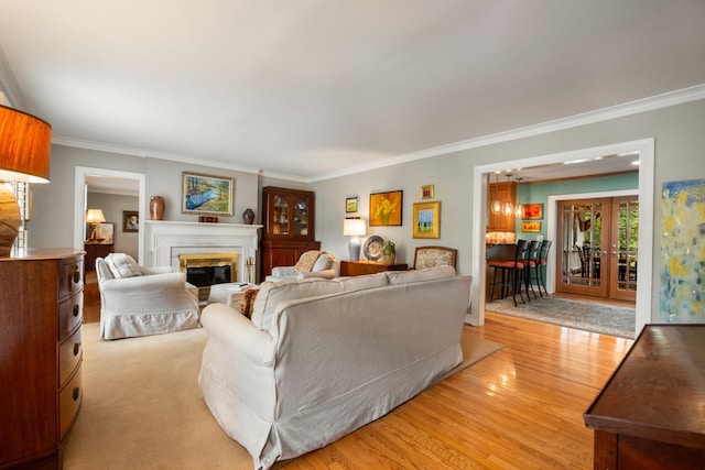 living room featuring crown molding, light hardwood / wood-style flooring, and french doors