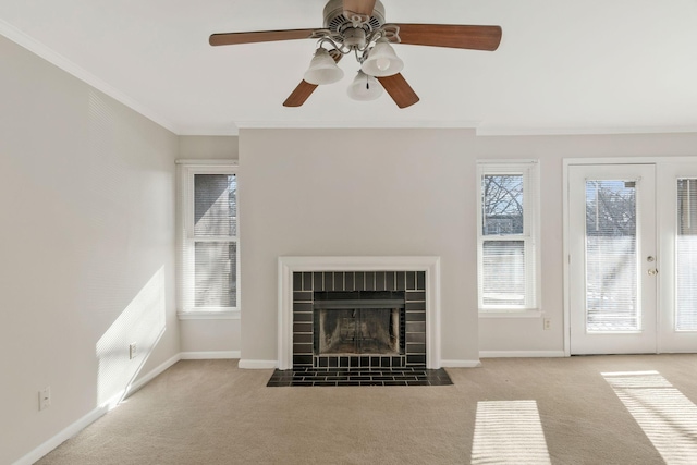 unfurnished living room with french doors, light carpet, ornamental molding, a tile fireplace, and ceiling fan