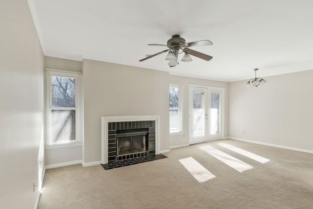 unfurnished living room featuring crown molding, light carpet, ceiling fan, and a fireplace