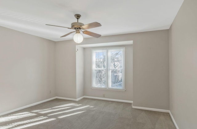 carpeted spare room featuring ceiling fan