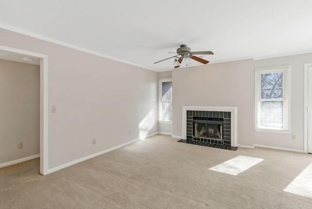 unfurnished living room with a tiled fireplace, crown molding, and light colored carpet